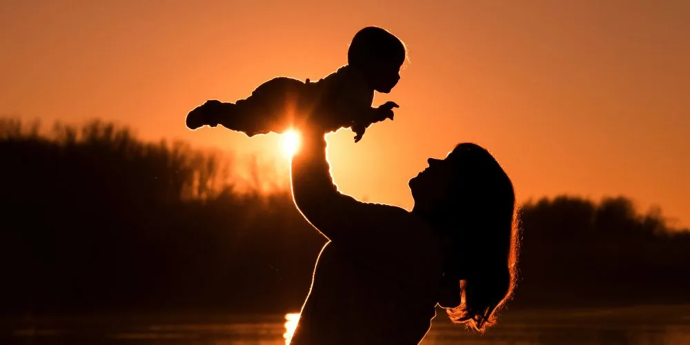 mother lifting baby silhouette