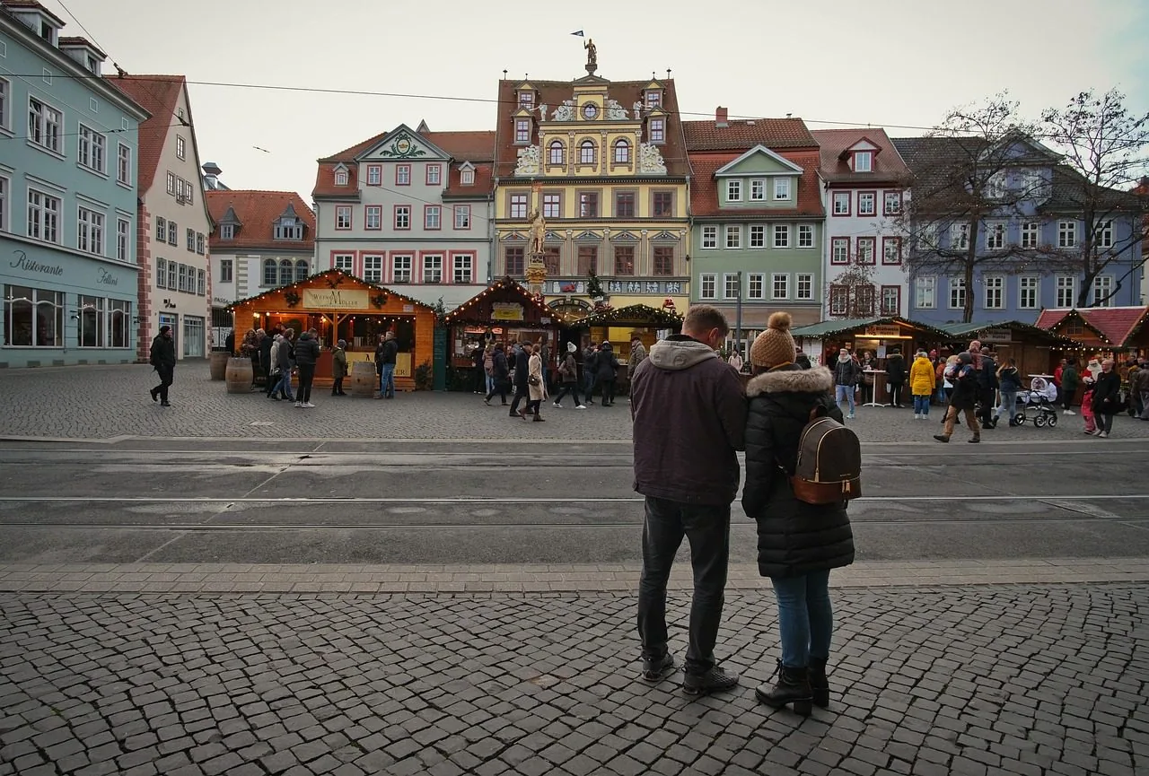 A snapshot of a location with a focus on a man and woman standing adjacent some colorful buildings