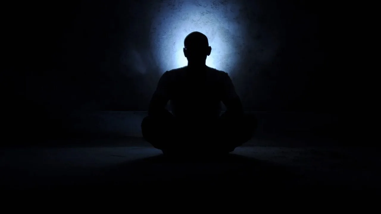 A silhouette of a man in yoga pose