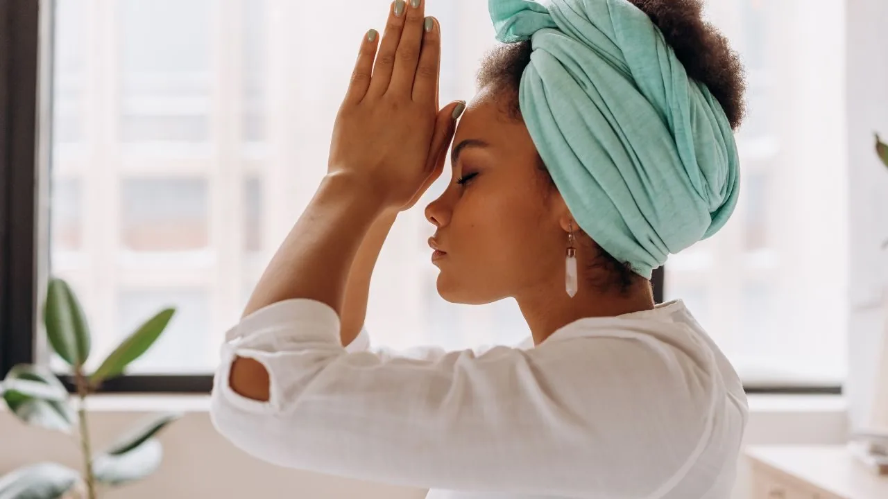 Woman with hands together against her head