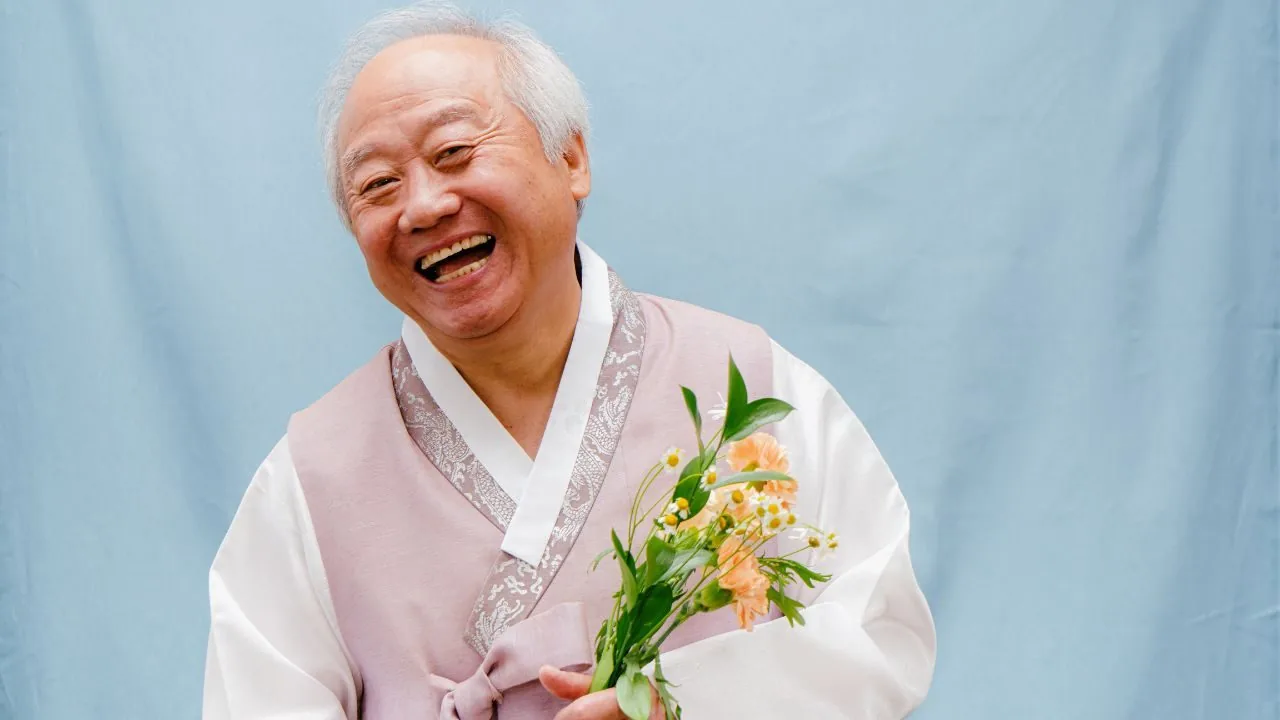 A senior Asian man laughing